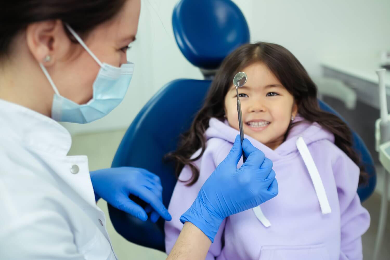 Dentist treating a young child in a dental chair.
