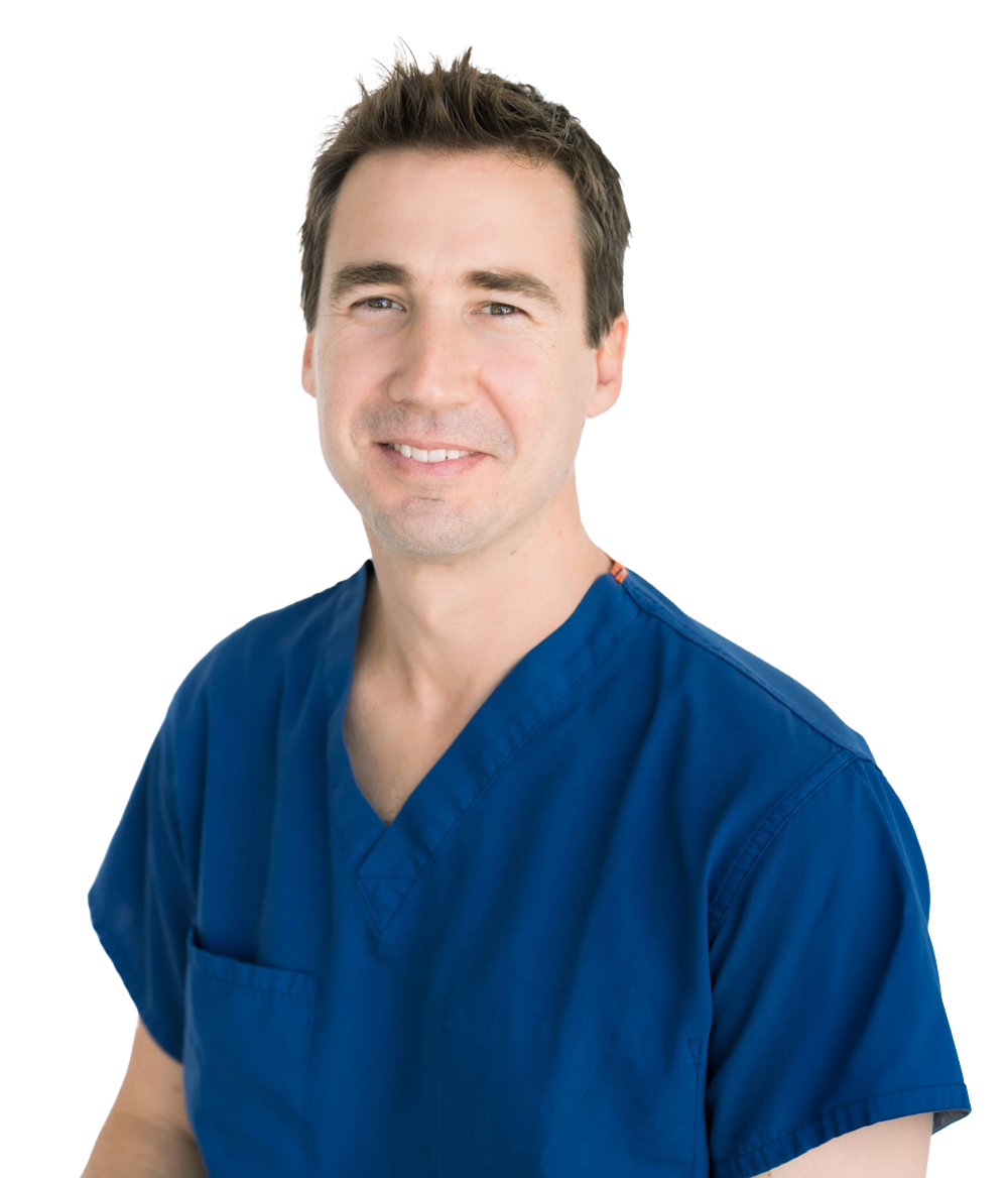 Dr. Garrett "Reed" Poole wearing blue medical scrubs in a dental office.